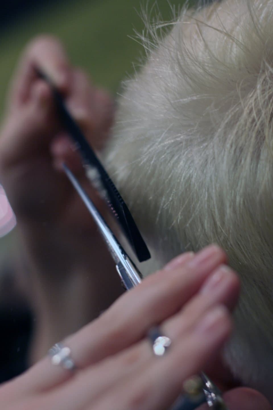 Stylist trimming hair with scissors